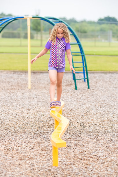 在户外操场上走平衡木的女孩图片下载