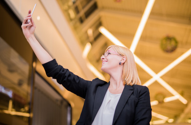 年轻优雅的女子在购物中心自拍图片下载