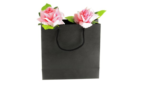 粉色玫瑰在黑色纸袋白色背景情人节概念图片下载