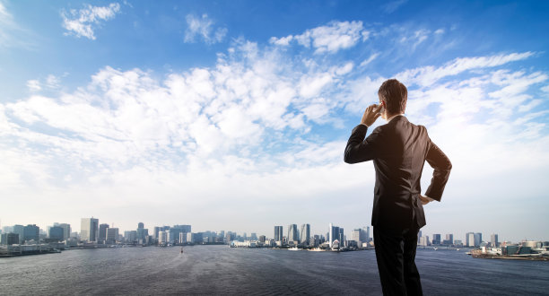 商务人士在电话中俯视城市景观。图片下载