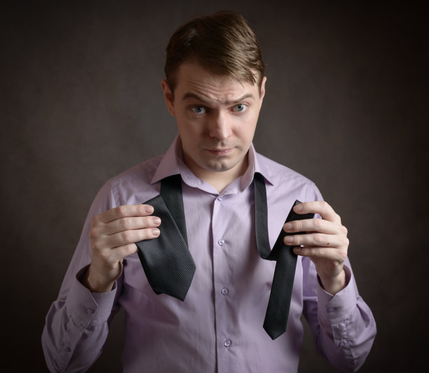 男人正在系领带。图片下载