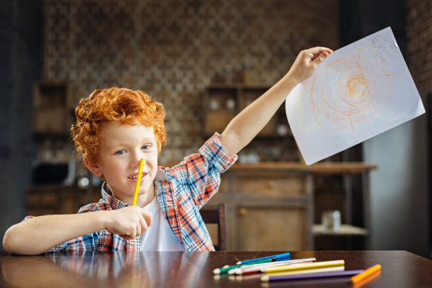 聪明的小男孩展示他的杰作图片下载