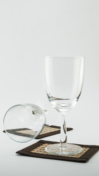 白色背景上有杯垫的雪利酒杯图片下载