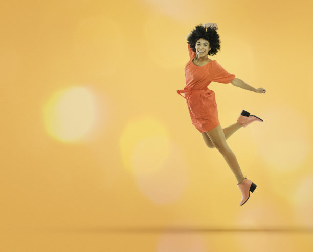 穿着裙子在跳跃的年轻女子图片下载