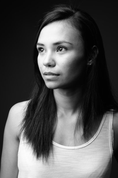 工作室拍摄的年轻亚洲女性在黑色背景下的黑白图片下载