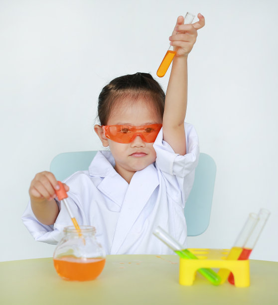 亚洲儿童在科学家制服拿着试管与液体，科学家化学和科学教育理念。图片下载