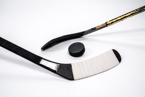 冰球和曲棍球棒在孤立的白色背景，复制空间。图片下载