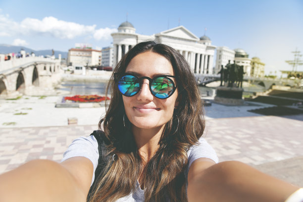 美丽的年轻女子旅游旅行者在城市自拍图片下载