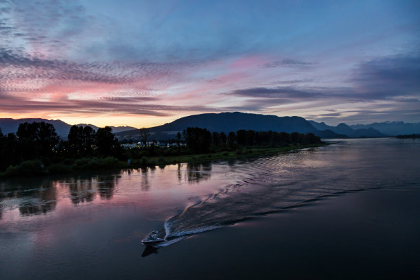 夕阳的余辉洒在河水上，呈现出粉红色图片下载