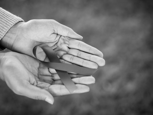 黑白手牵红丝带，世界艾滋病日宣传丝带。医疗保健理念。图片下载