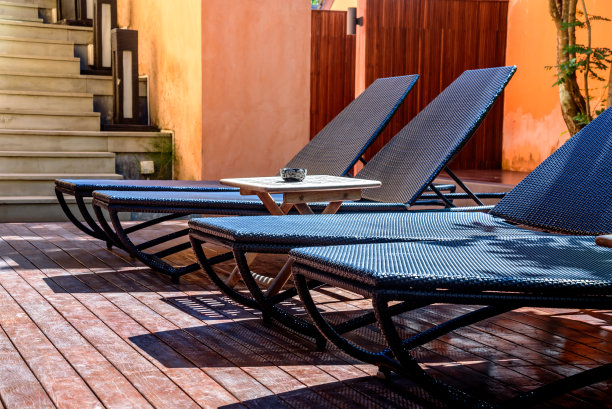 舒适的藤椅在现代热带室外游泳池图片下载