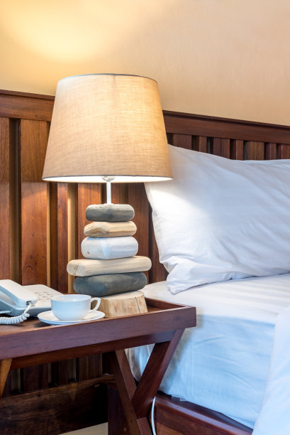 现代热带卧室木质床头板上灯罩特写图片下载