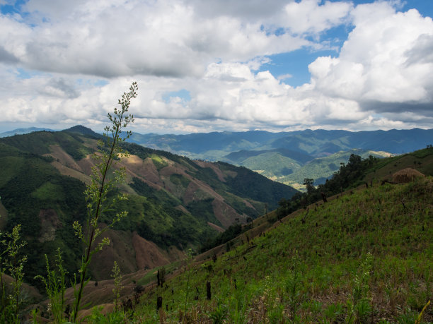 绿色和棕色的山坡与自然的多云的天空的风景照片。这个地点是在徒步前往泰国南省Doi Phu Wae山顶的路上图片下载