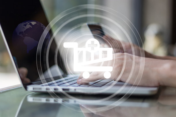 手持信用卡在笔记本电脑上进行网上购物的电子商务概念素材图片