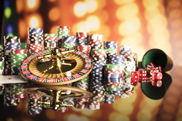 赌场的主题。高对比度图像赌场轮盘赌，扑克游戏，骰子游戏，扑克筹码在赌桌上，所有在彩色的散景背景。图片下载