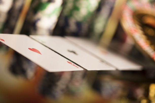 赌场的主题。高对比度图像赌场轮盘赌，扑克游戏，骰子游戏，扑克筹码在赌桌上，所有在彩色的散景背景。图片下载