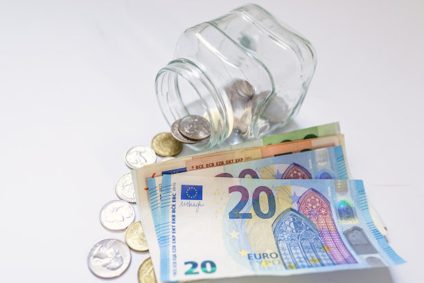 储蓄，金钱，年金保险，退休和人的概念。25、钱与储蓄相存，孤立于白色。在白色的背景上孤立的玻璃罐中节省欧元图片下载