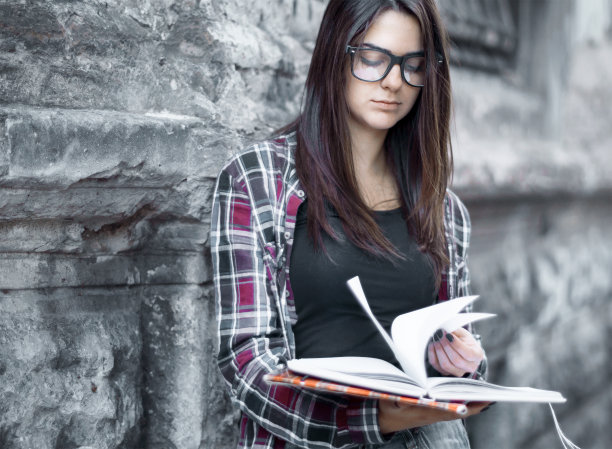 漂亮的女学生带着书在户外工作图片下载