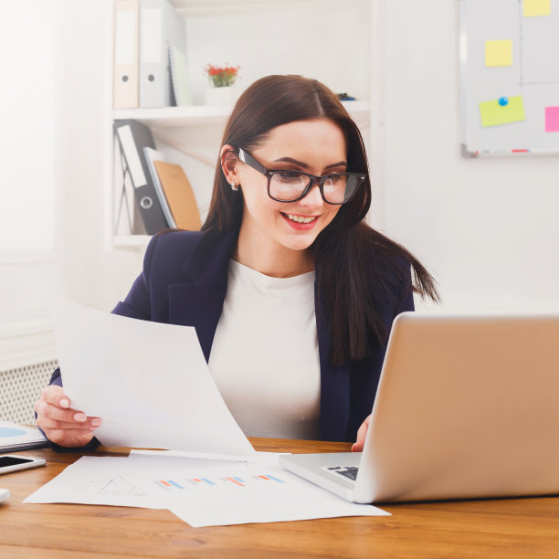 商务女性在办公桌前阅读文件图片下载