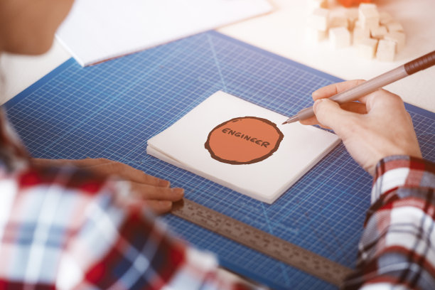 一名女子在记事本上画着一幅写着“工程师”的画图片下载