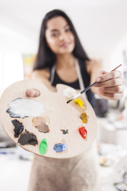 微笑画家的肖像与调色板和画笔图片下载