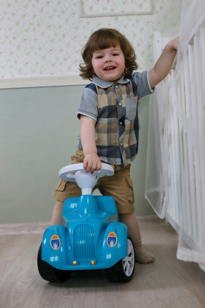 小男孩坐在玩具车上图片下载