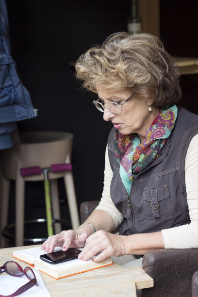 老妇人在咖啡厅看书图片下载