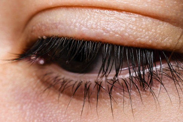 特写美丽的眼睛与棕色的虹膜和眼睫毛看远离相机图片下载