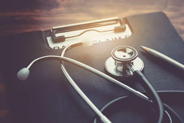 健康保险理赔表与听诊器在木桌上选择性聚焦素材图片