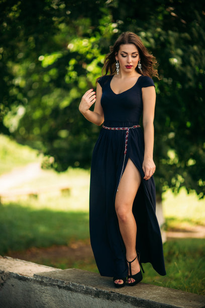 一个穿着蓝色裙子的漂亮女孩正在公园里散步。图片下载