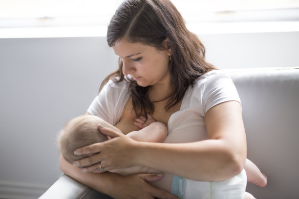 妇女在床上给婴儿喂奶图片下载