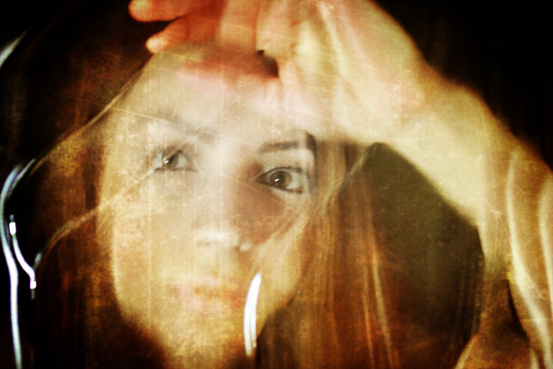 在肮脏的玻璃后面，照片女孩的脸被刮得很脏图片下载