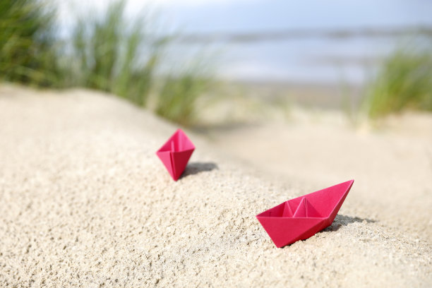 荷兰海岸线上的沙丘和红色的折纸船图片下载