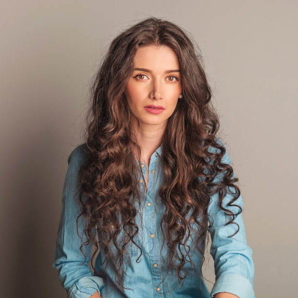 穿着牛仔裤衬衫的严肃年轻女人图片下载