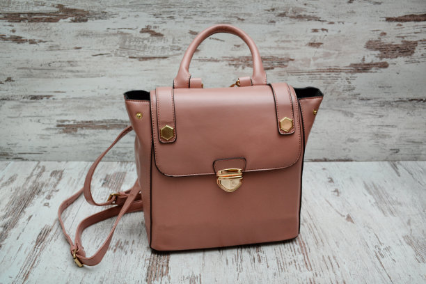 木质背景上的深粉色包。时尚的概念。图片下载