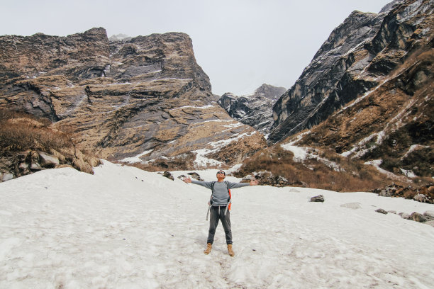 背着背包在山里徒步旅行的男人。天气寒冷，山上有雪。冬季徒步旅行。复古效果风格的图片。图片下载