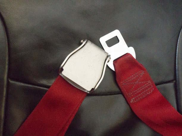 红色安全带在飞机上，在空中飞行时拯救生命。安全旅游理念。图片下载