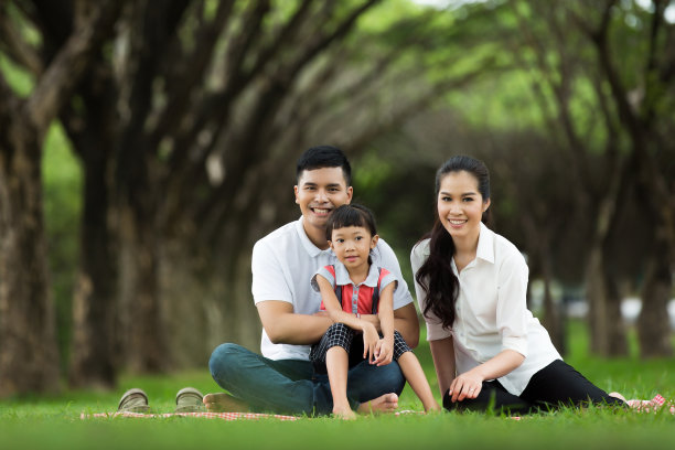 一个亚洲家庭坐在公园里。幸福的图片下载