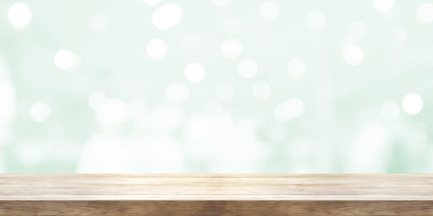 空的木制桌面与模糊的浅绿色自然抽象背景。全景横幅。可用于产品展示。素材图片