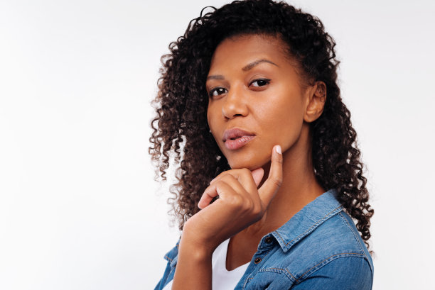 漂亮的黑发姑娘用手指摸着下巴图片下载