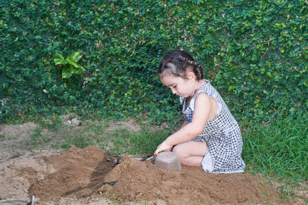 小女孩在后院的沙滩上玩耍图片下载