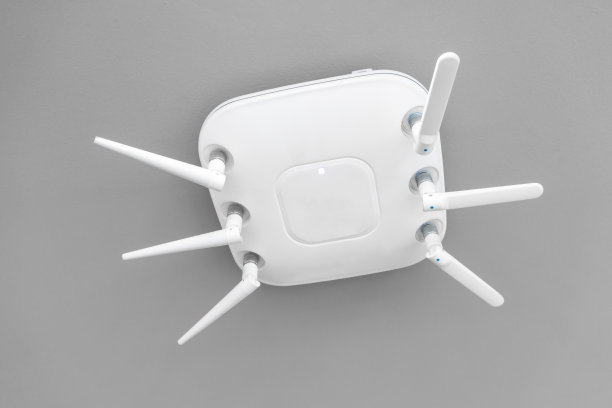 网络无线路由器挂在白色天花板上。素材图片