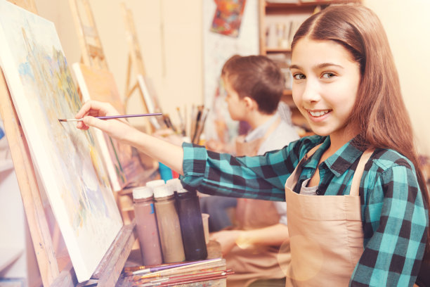 微笑的女孩拿着画笔看着相机图片下载