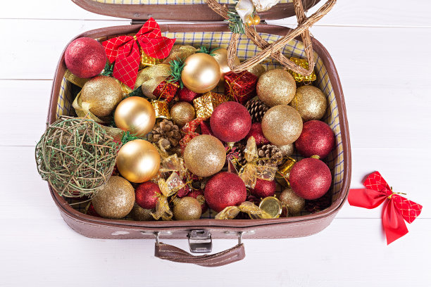 白色背景下装圣诞玩具的旧手提箱图片下载