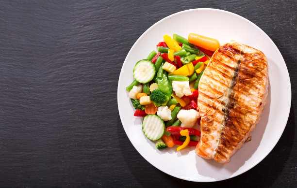 一盘烤鲑鱼排配蔬菜素材图片