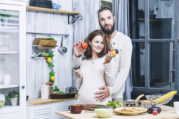 年轻漂亮的异性恋夫妇夫妇怀着身孕在家厨房做饭图片下载
