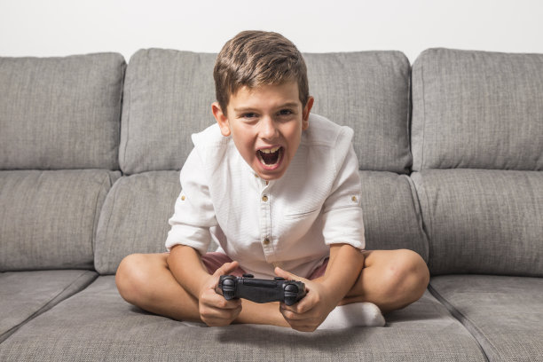 男孩在家里玩游戏机图片下载