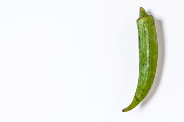 在白色背景上分离的新鲜的小秋葵。现esculentus。白色背景上的绿色玫瑰。篮子里的新鲜秋葵汤素材图片
