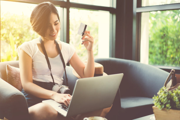 女性亚洲旅行者她在网上或飞机上购物。在咖啡店用信用卡付账图片下载