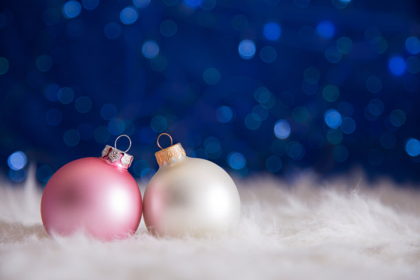 白色和粉红色的圣诞球毛皮与花环灯在蓝色的散焦背景图片下载